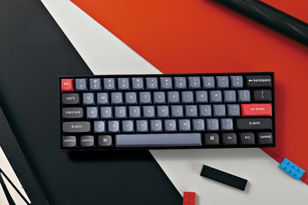 KEYCHRON K6 HE baterię o pojemności 4000 mAh  (do 130 z podświetleniem, oraz do 260 bez podświetlenia) - klawiatura na biało niebieskim podłożu, obok aparat - klawiatura na czerwono-biało-czarnym podłożu