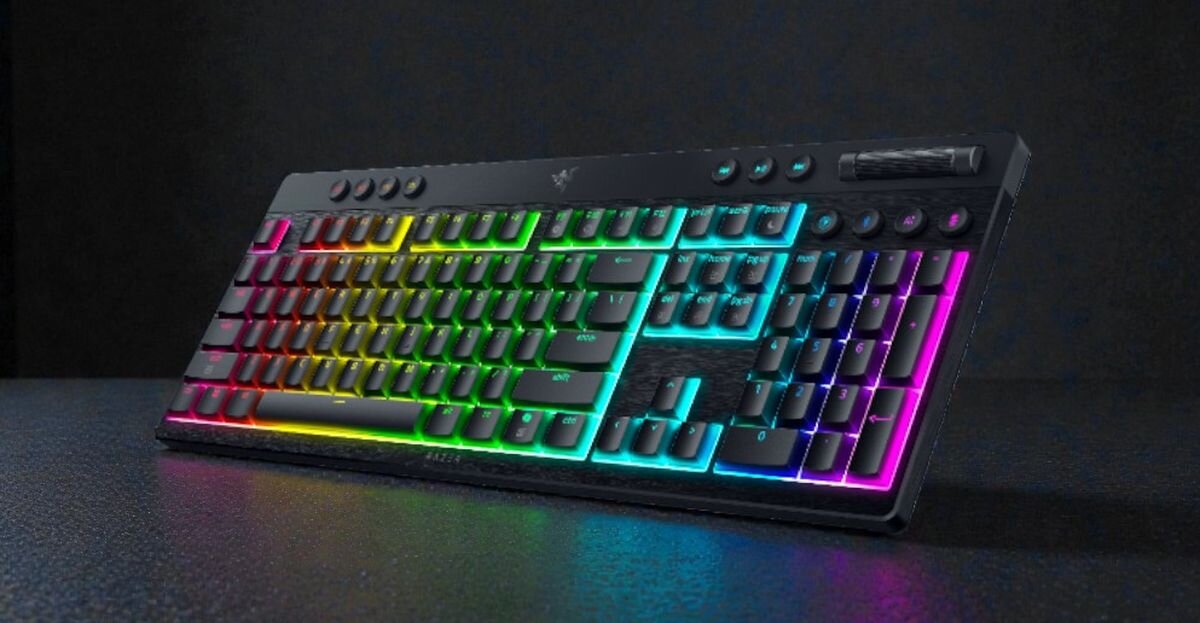 Klawiatura mechaniczna z podświetleniem RGB, posiadająca klawisze w różnych kolorach tęczy. Na górnej części widoczne jest logo producenta.
