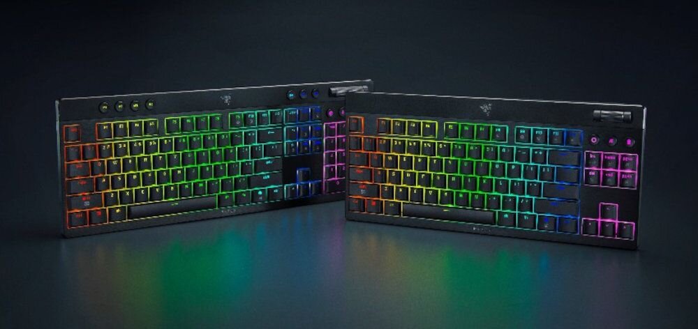 Dwie klawiatury z podświetleniem RGB, każda z widocznym logo producenta na górze. Klawisze mają różnokolorowe podświetlenie, a na górnej części znajdują się dodatkowe przyciski i pokrętła.