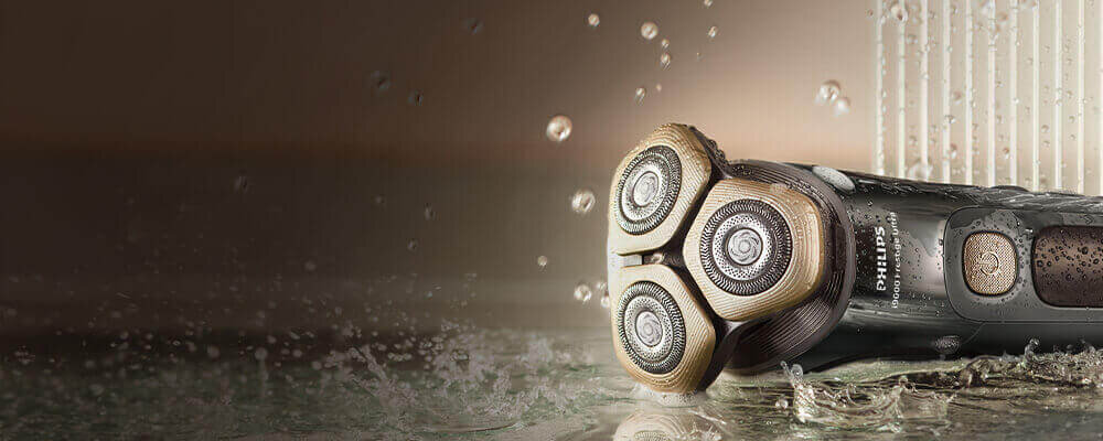 Srebnoniebieska golarka na półce. Na golarce krople wody.