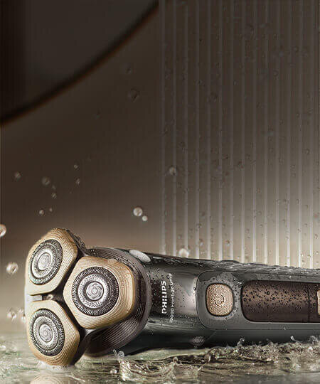 Srebnoniebieska golarka na półce. Na golarce krople wody.