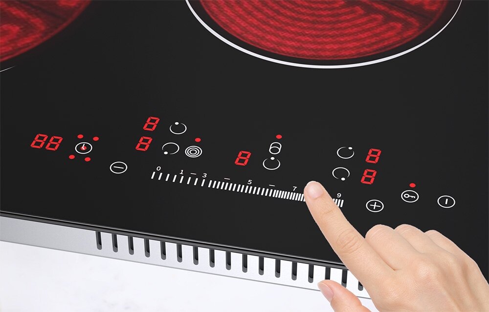 Płyta ceramiczna ISEASY LT5-02 Palec wybiera poziom mocy na panelu sterowania, gdzie widoczna jest podziałka numeryczna i czerwone wskaźniki. Ujęcie skupia się na precyzyjnej regulacji ustawień panel dotykowy slider regulacja mocy