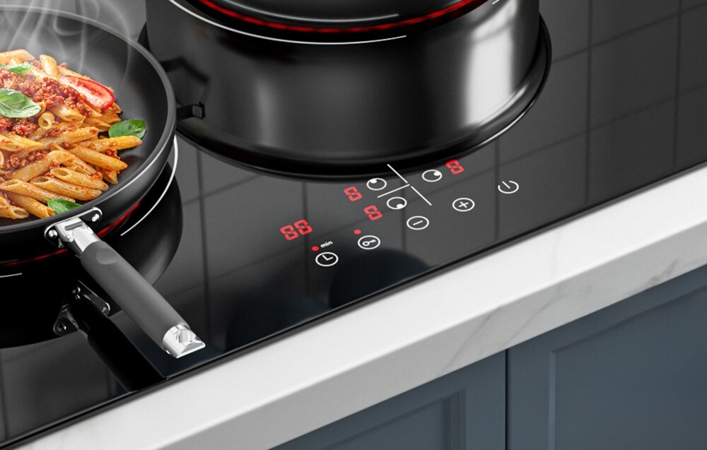 Płyta ceramiczna ISEASY LT3-22 Zbliżenie na panel sterowania pokazuje czerwone cyfry i aktywne funkcje podczas gotowania makaronu w patelni. Obok stoi większy garnek na drugim polu grzewczym panel dotykowy sterowanie regulacja mocy