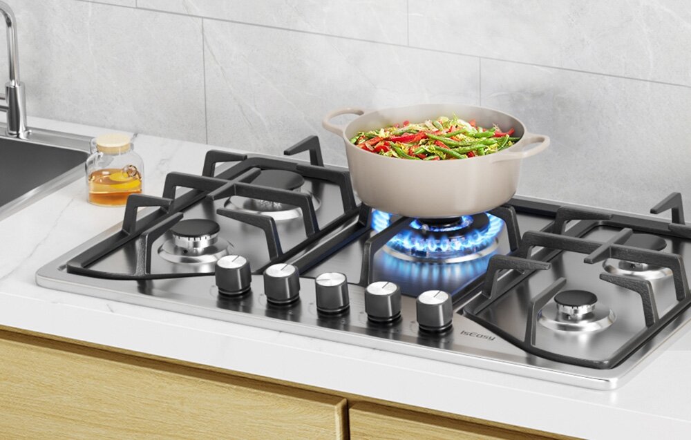 Płyta gazowa ISEASY MGBS-765 Garnek wypełniony warzywami gotuje się na mocnym płomieniu, ustawiony na środkowym palniku. Obok znajdują się dodatkowe palniki gotowe do użycia stal nierdzewna 201 żeliwne ruszty trwała konstrukcja łatwe czyszczenie pokrętła bakelitowe