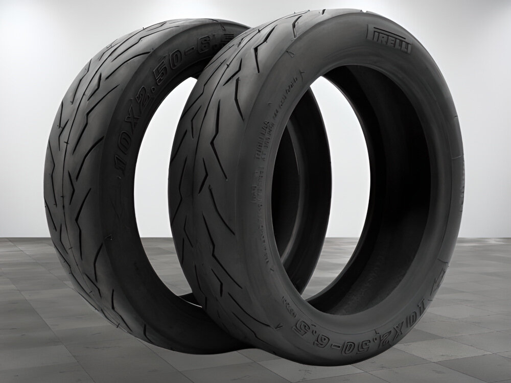 Dwie czarne opony z widocznym bieżnikiem, na jednej z nich widnieje napis \'PIRELLI\'.