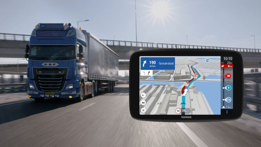 Na obrazie widać ciężarówkę jadącą po drodze oraz urządzenie nawigacyjne z mapą i wskazówkami trasy. Na ekranie nawigacji widoczny jest tekst: \'190 meters, Taanstraat\', a w prawym górnym rogu godzina \'10:10\'.