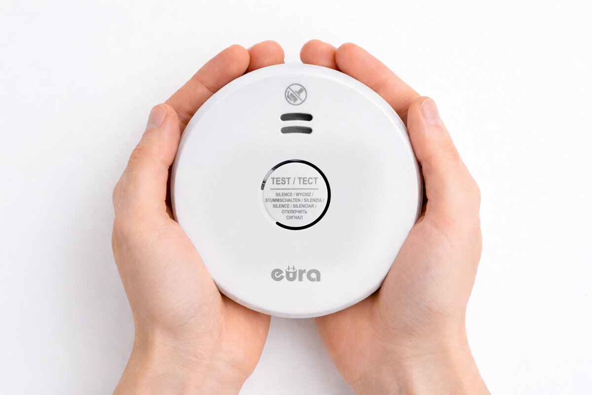 Czujnik dymu EURA SD-09A2, pożar, ogień, wykrycie, wsparcie, Biały Czujnik dymu EURA SD-09A2 trzymany w dłoniach.