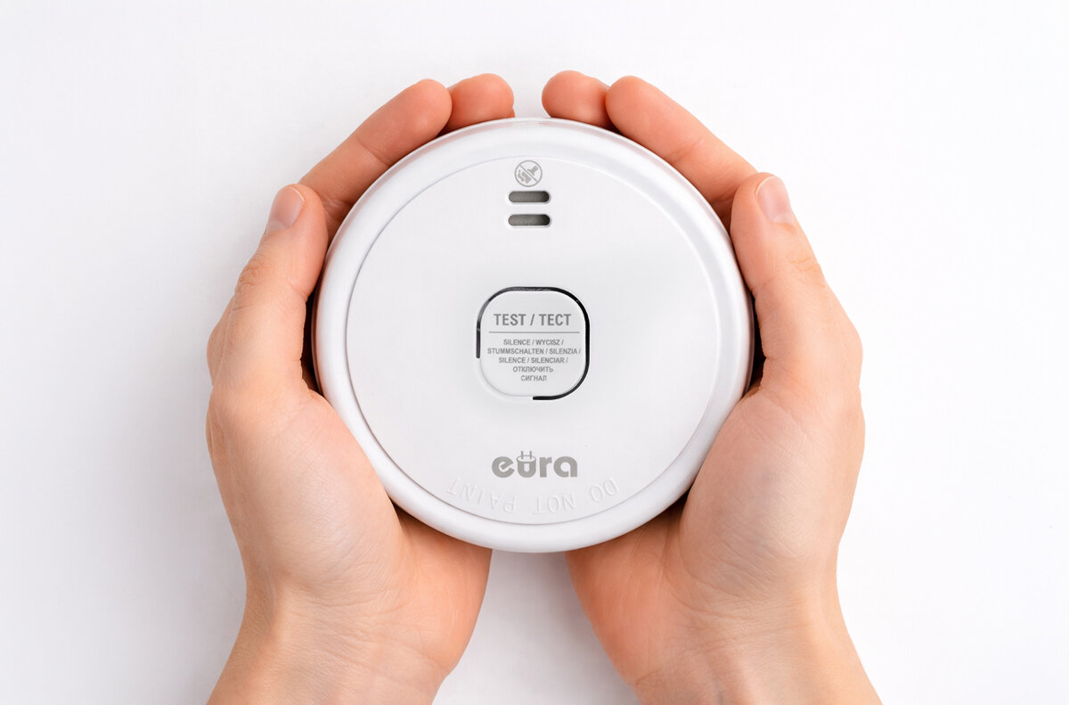 Czujnik dymu EURA SD-08A2, pożar, ogień, wykrycie, wsparcie, Biały czujnik dymu EURA SD-08A2 trzymany w dłoniach.