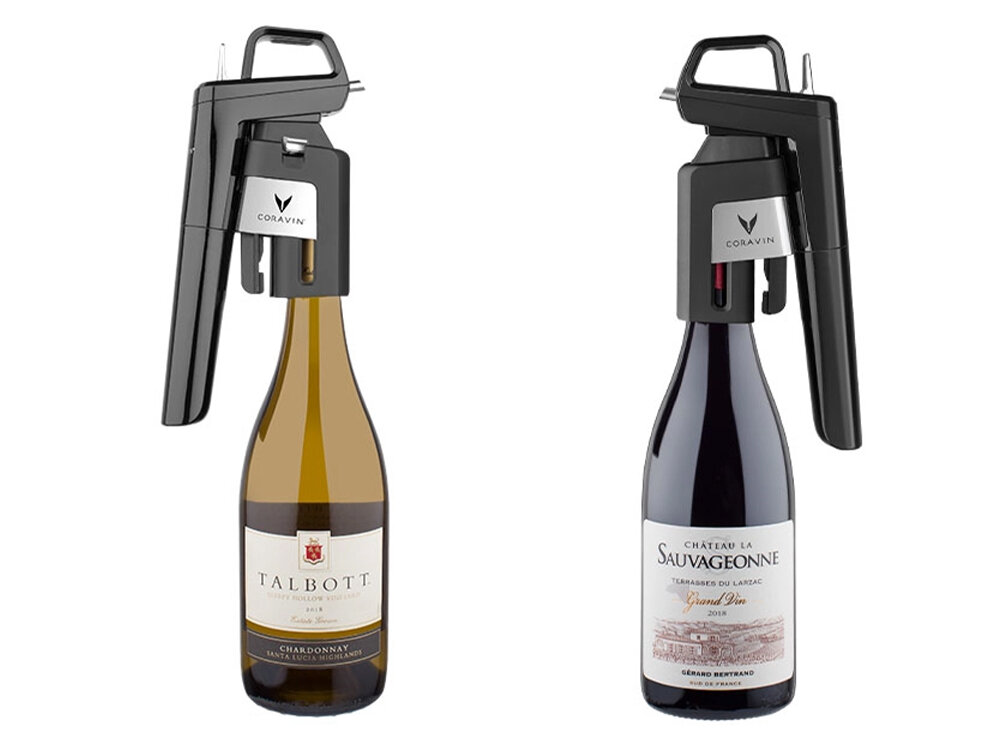 Na obrazie widoczne są dwie butelki wina z zamontowanymi systemami do przechowywania wina marki CORAVIN. Na etykietach butelek widnieją napisy: \'TALBOTT\' oraz \'CHÂTEAU LA SAUVAGEONNE\'.