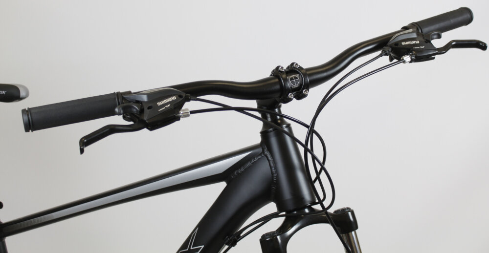 Rower górski MTB SIROX Siron M19 27.5 cala męski Czarny mat zbliżenie na kierownicę jasne tło aluminiowa kierownica SIROX szerokość 720 x 31,8 mm aluminiowy wspornik SIROX Ahead stabilność precyzja prowadzenia antypoślizgowe uchwyty kontrola nad rowerem i bezpieczeństwo waga roweru 15,5 kg