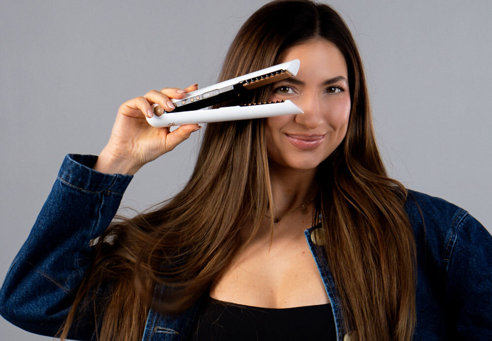 Prostownica SKINVIBE Luna Miniwireless SV-003WH Biały 210 stopni jasne tło kobieta w ciemnych włosach pozuje z białą prostownicą otwarta kobieta się uśmiecha trzy ustawienia temperatury dostosowanie minimalizacja uszkodzeń i przesuszenia 165 stopni wygładzenie cienkich i wrażliwych włosów subtelny naturalny efekt 185 stopni optymalna temperatura codzienne prostowanie wygładzanie nadanie blasku 210 stopni intensywne ciepło dla wymagających stylizacji długotrwałe efekty stylizacji