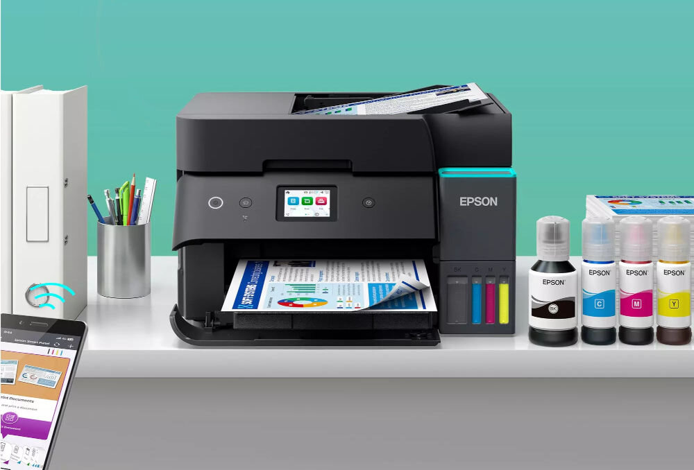 Drukarka EPSON EcoTank L6390 Druk w kolorze, Automatyczny druk dwustronny, Wi-Fi prezentacja urządzenia na szafce obok butelki z atramentem wystający telefon z włączoną aplikacją uzupełnianie atramentu ecotank system bez kartridży redukcja odpadów pojemniki na atrament