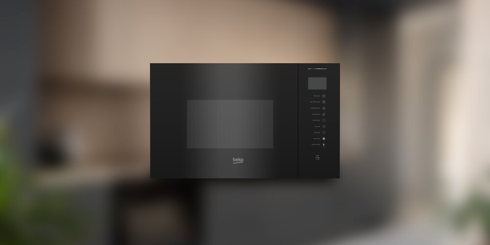 KUCHNIA MIKROFALOWA BEKO BMGB25353B Kuchenka mikrofalowa Beko na rozmytym tle kuchni. Prosty, stalowy design