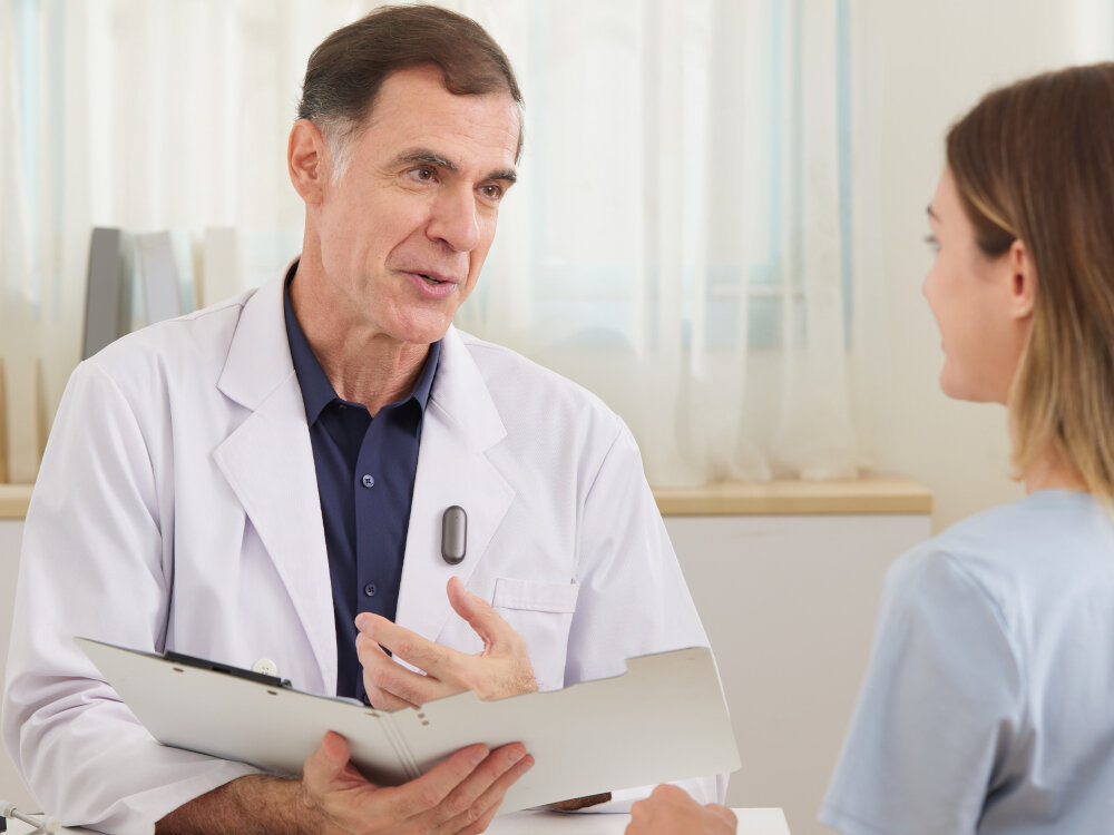 Dyktafon AI PLAUD NotePin nagrywanie 20h tryb czuwania 40dni Google Microsoft, osoba z przypiętym dyktafonem