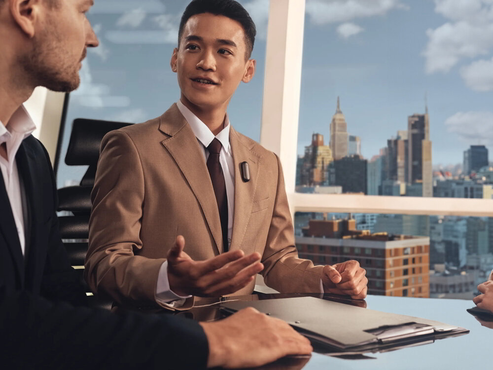 Dyktafon AI PLAUD NotePin nagrywanie transkrypcja podsumowanie, osoby uczestniczące w spotkaniu biznesowym, osoba z przypiętym dyktafonem