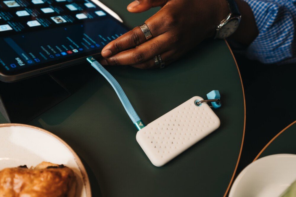 Dysk VERBATIM Pocket Widok z góry na dysk zewnętrzny ułożone na stole obok laptopa i tabletu, z podłączonymi krótkimi kablami tworzącymi kąty proste, interfejs, prędkość