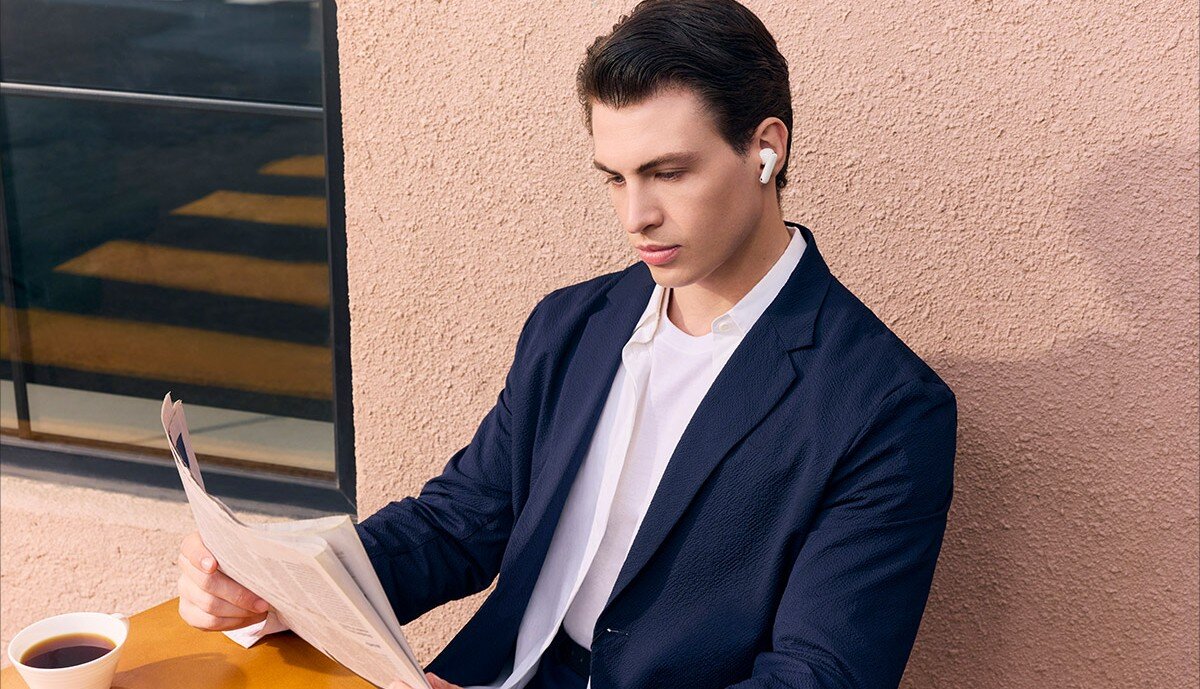 OPPO Enco X3s ANC automatyczna optymalizacja transparentność otoczenia, Młody mężczyzna w słuchawkch w kawiarnianym ogródku