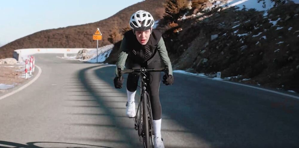 Słuchawki SHOKZ OpenSwim Pro IP68 pływanie do 2 m przez 2 godziny tryb Bluetooth MP3, osoba z założonymi słuchAwkami kostnymi jadąca na rowerze