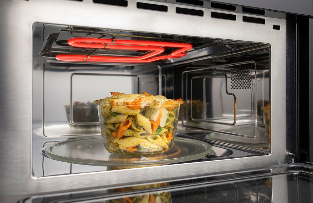 KUCHNIA MIKROFALOWA HISENSE BIM334G64DBG8 Wnętrze kuchenki mikrofalowej z widoczną, rozgrzaną grzałką grilla nad naczyniem z zapiekanką ilustruje połączenie funkcji mikrofali i grilla w jednym urządzeniu grill z mikrofalą funkcja grill mikrofalówka szybkie gotowanie chrupiące potrawy mięso pizza równomierne podgrzewanie Grill i mikrofala w jednym