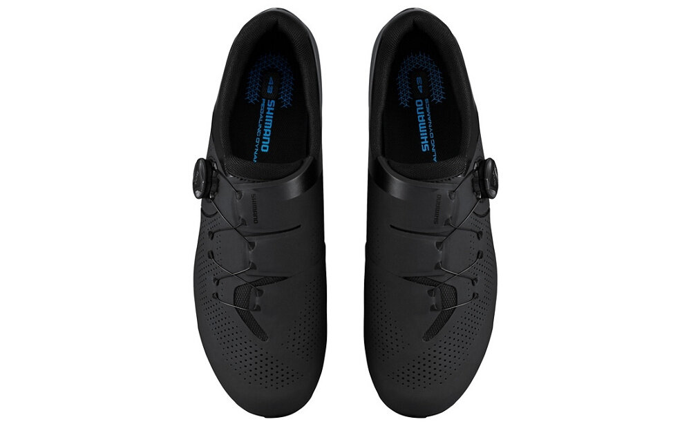Czarne buty rowerowe z zapięciem na pokrętło, widoczne z góry. Wnętrze butów ma niebieski napis \'SHIMANO\'.