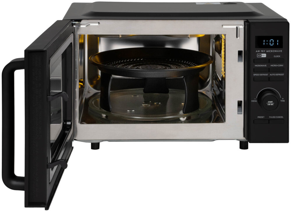 Kuchenka mikrofalowa GÖTZE & JENSEN MO920KAF Twin AirFry 1200W średnica 34.5 cm pojemność 20L Auto Defrost Quick Start Czarny blat w kuchni kuchenka stoi na blacie osoba trzyma palec na przycisku tryb kombinowany funkcja mikrofalówki z konwencją o mocy 1680 W łączy działanie mikrofal i gorącego powietrza skraca czas przygotowania potraw pięknie zrumienią powierzchnię 11 poziomów mocy można dopasować intensywność pracy do rodzaju składników i wybranego sposobu przygotowania