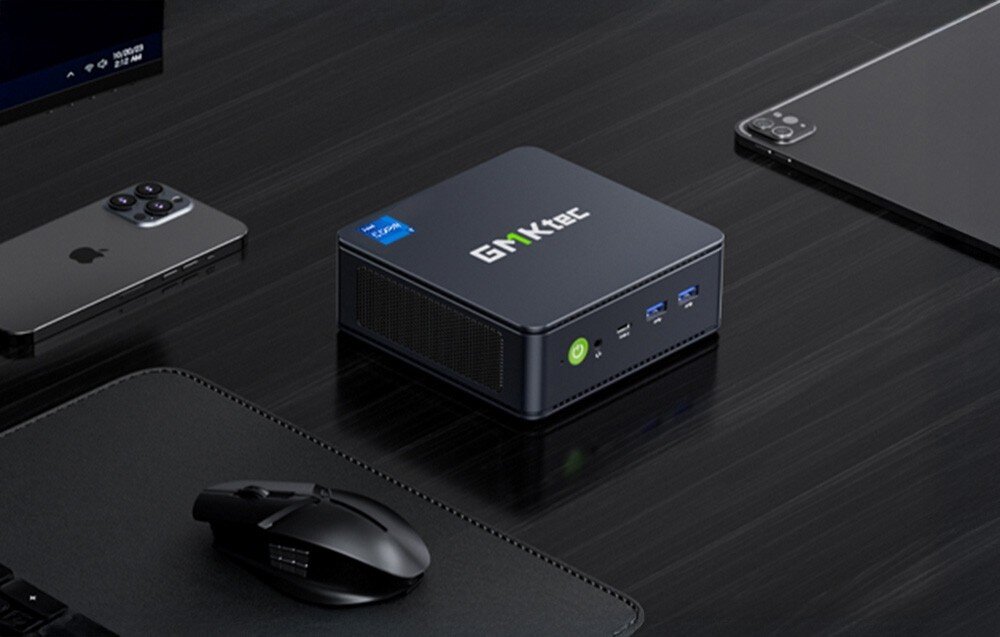 Komputer GMKTEC K7 Plus Komputer umieszczony na czarnym biurku obok myszy, telefonu i tabletu, dysk, pojemność, szybkość