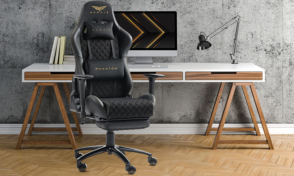 Fotel GAMVIS Phantom Large Czarny (złote elementy) + podnóżek prezentacja fotela na tle pokoju w tle biurko z monitorem i akcesoriami szara ściana imitująca beton wielozadaniowy komfort biuro