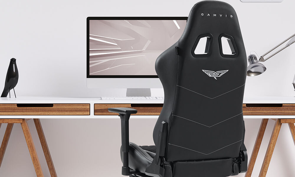 Fotel GAMVIS Phantom Large Czarny (białe elementy) + podnóżek prezentacja fotela w pokoju przy biurku jasna ściana monitor lampka akcesoria wyścigowy charakter elegancja fotel klasy premium niezliczone godziny przed ekranem