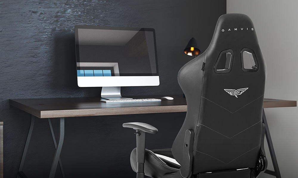 Fotel GAMVIS Expert Czarny (białe elementy) prezentacja fotela w pokoju przy biurku monitor stojący na biurku z akcesoriami komputerowymi lampka obok wielozadaniowość fotel biurowy gamingowy komfort