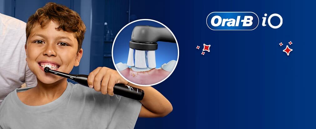 Uśmiechnięte dziecko szczotkujące zęby szczoteczką Oral-B iO Kids 6+; zbliżenie na szczoteczkę elektryczną czyszczącą jego zęby