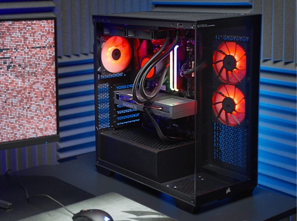 Komputer OPTIMUS E-Sport GB550T-CR9 widok z boku na wnętrze włączonego komputera z podświetlonymi na pomarańczowo wentylatorami, dwoma świecącymi modułami pamięci oraz kartą graficzną, przeznaczenie, zalety, cechy