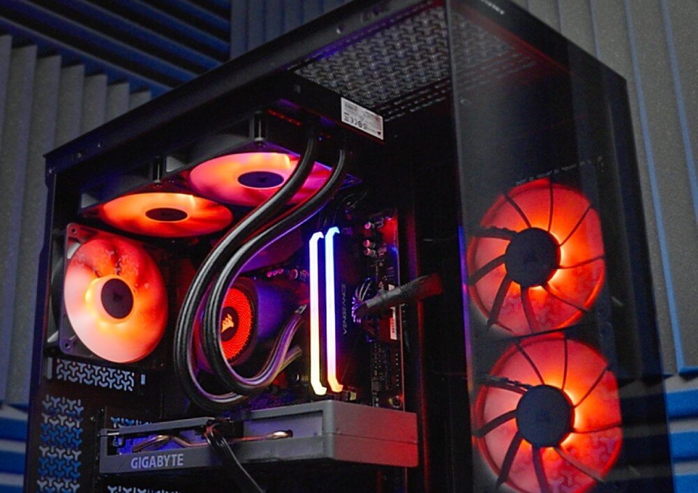 Komputer OPTIMUS E-Sport GB650T-CR4 zbliżenie na górną część wnętrza komputera ukazujące trzy podświetlone wentylatory, chłodzenie wodne procesora oraz dwa pionowe paski świecącej pamięci ram, procesor, rdzenie, taktowanie