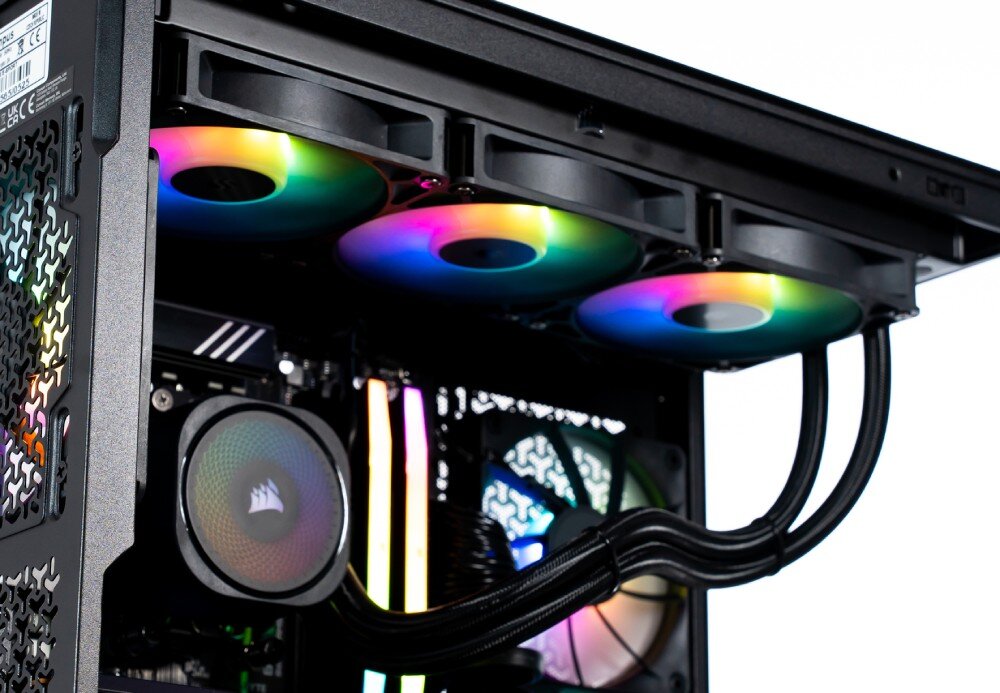 Komputer OPTIMUS E-Sport GB650T-CR4 Widok z boku na górną sekcję wnętrza komputera z trzema wentylatorami chłodnicy podświetlonymi na kolory tęczy, blokiem wodnym na procesorze oraz pionowymi modułami pamięci RAM, chłodzenie, wentylatory