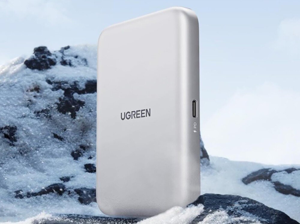 Obudowa dysku UGREEN D619 Srebrna, prostokątna obudowa z zaokrąglonymi rogami i napisem Ugreen ustawiona pionowo na tle ośnieżonych skał. Na bocznej krawędzi widoczny jest port USB-C z oznaczeniem błyskawicy oraz literami 'PD'