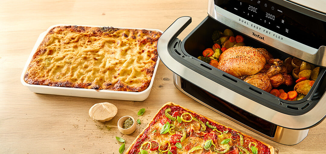Frytkownica beztłuszczowa EY922D z pieczonym kurczakiem i warzywami obok pizzy oraz zapiekanki.