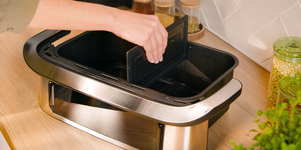 Osoba montuje separator do dwóch stref gotowania w szufladzie frytkownicy Dual Easy Fry Flex EY922D.