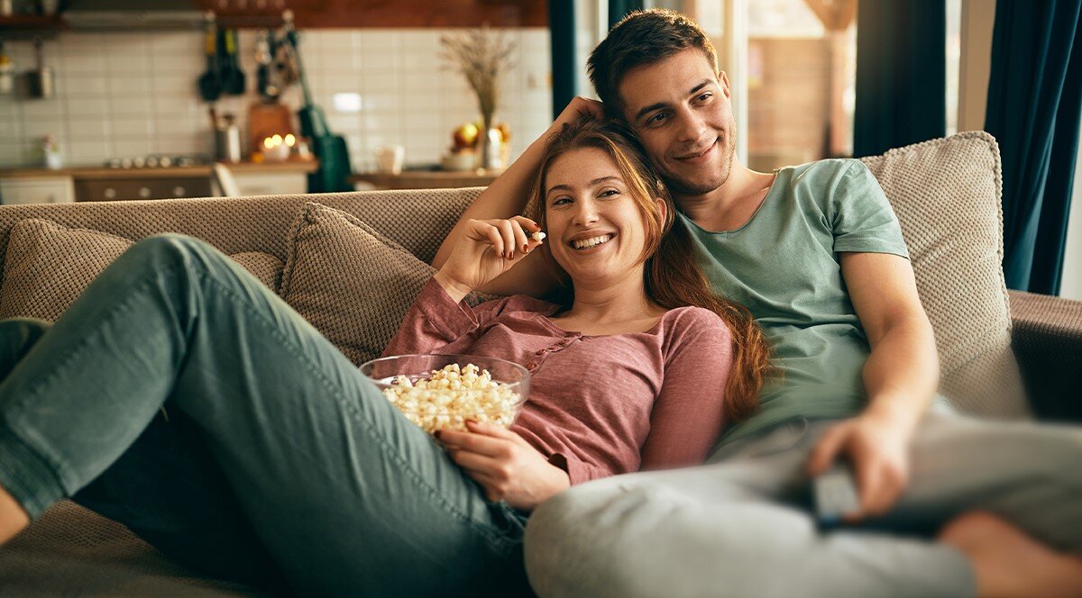 Soundbar SHARP HT-SBW312 Dolby Atmos, DTS, subwoofer, głęboki bas, kino domowe, osoby siedzące na kanapie zajadające popcorn