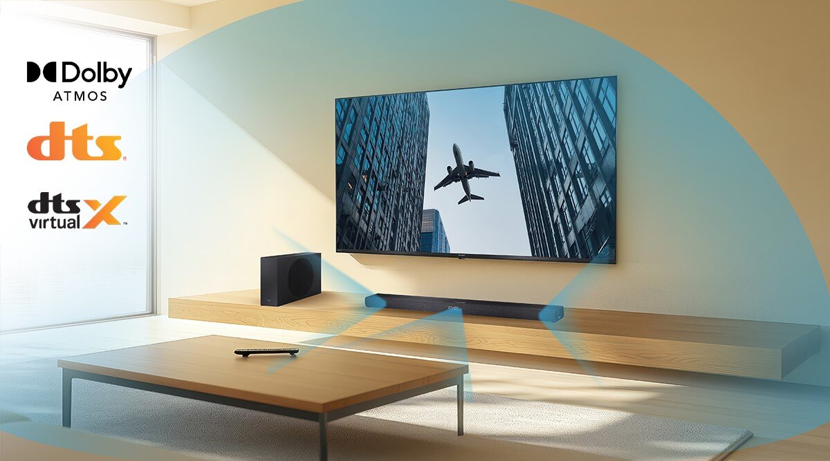 Soundbar SHARP HT-SBW320 Dolby Atmos DTS Virtual:X, surround, trójwymiarowy dźwięk, soubndbar stojący na drewnianej desce pod zawieszonym telewizorem