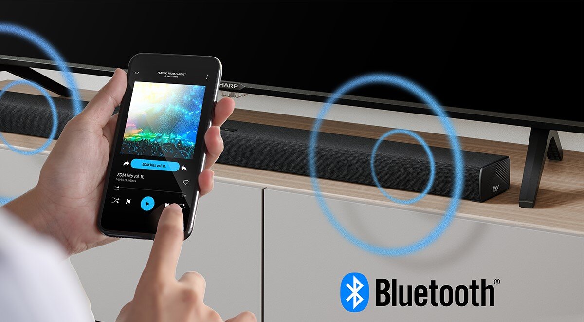 Soundbar SHARP HT-SBW320 Bluetooth 5.3, bezprzewodowe odtwarzanie, smartfon, tablet, osoba trzymająca smartfon w ręku, soudbar stojący na szafce