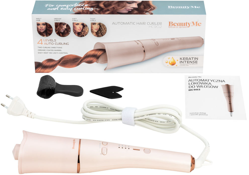 Na obrazie znajduje się automatyczna lokówka BEAUTYME HC902 w kolorze różowego złota, z widocznym kablem zasilającym oraz akcesoriami. W tle znajduje się pudełko z grafiką przedstawiającą lokówkę i różne style loków, a także ulotka z napisem \'AUTOMATYCZNA LOKÓWKA DO WŁOSÓW HC902\'.
