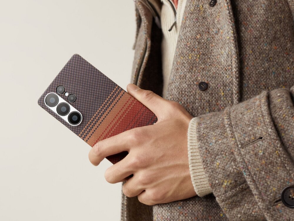 Etui PITAKA Ultra-Slim MagSafe
                telefon z etui trzymany w dłoni przy uchu na jasnym tle