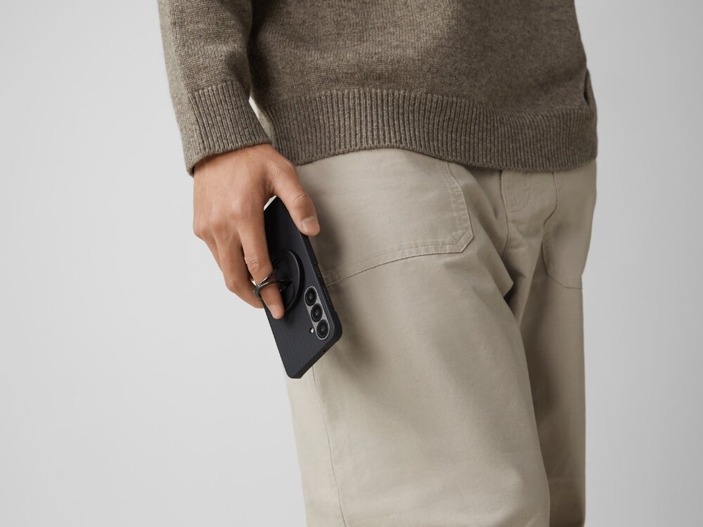 Etui PITAKA Ultra-Slim MagSafe
                telefon z etui trzymany w dłoni przy uchu na jasnym tle