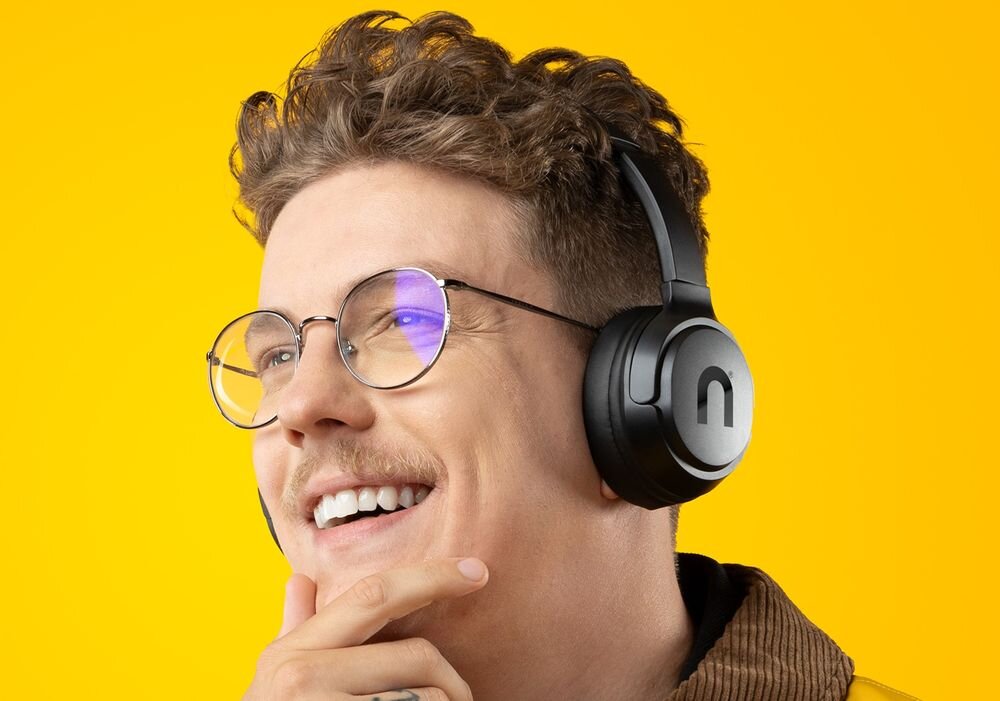 Słuchawki nauszne NICEBOY Hive Prodigy 4 MaxxBass głęboki bas przetworniki 40 mm, osoba z założonymi słuchawkami nausznymi na żółtym tle