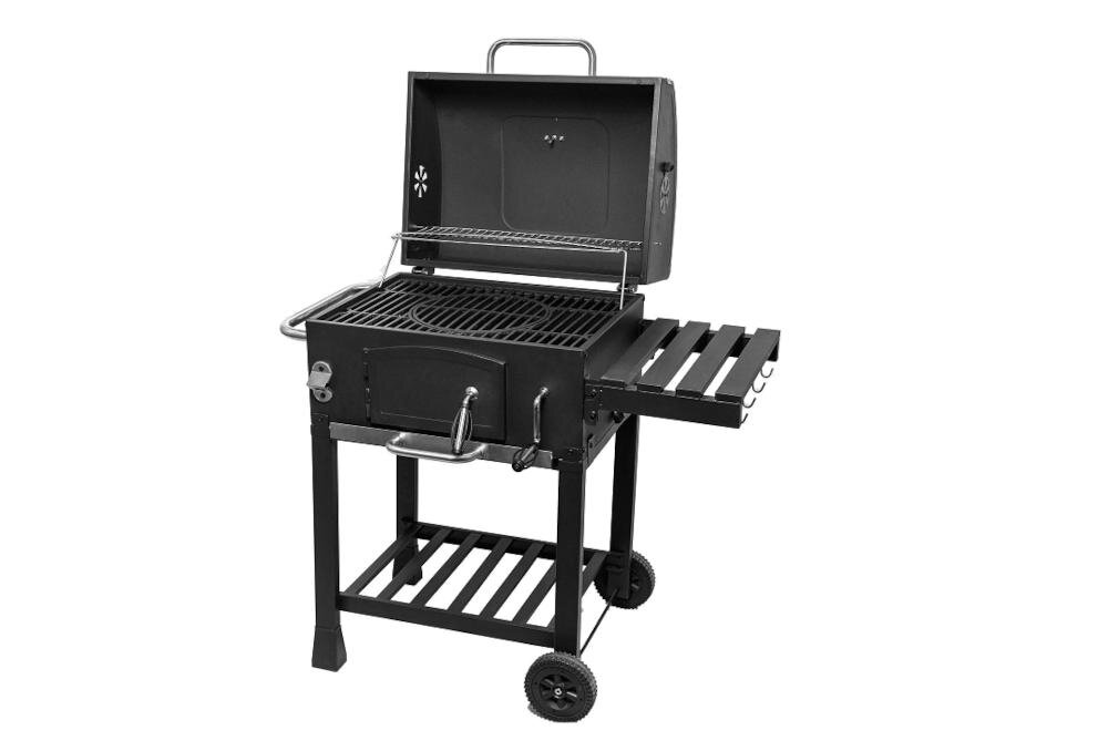 Na zdjęciu widoczny jest czarny grill węglowy z otwartą pokrywą, posiadający ruszt i boczną półkę. Grill stoi na dwóch kołach i ma dolną półkę na akcesoria.