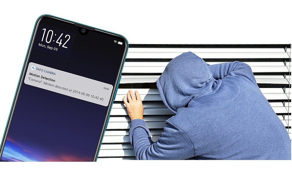 Na obrazie widać smartfon z powiadomieniem od aplikacji \'TAPO CAMERA\' o wykryciu ruchu oraz osobę w niebieskiej bluzie przy żaluzjach. Na ekranie telefonu widoczna jest godzina 10:42 i data Mon, Sep 09.