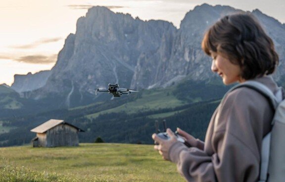 Kobieta sterująca dronem na dworze.