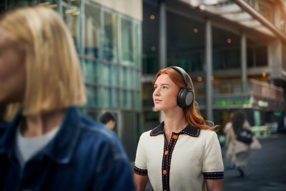 PHILIPS TAH8000EBK/00 słuchawki nauszne komfort, wysokiej jakości dźwięk, wymienna bateria, osoba z założonymi słuchawkami nausznymi w plenerze