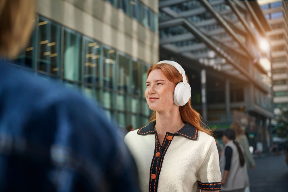 PHILIPS TAH8000EWT/00 słuchawki nauszne komfort, wysokiej jakości dźwięk, wymienna bateria, osoba z założonymi słuchawkami nausznymi w plenerze