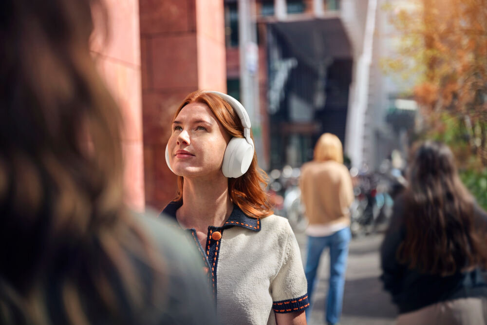 PHILIPS TAH8000EWT/00 słuchawki ciepły dźwięk, szczegółowe tony, głęboki bas, osoba z założonymi słuchawkami nausznymi w plenerze