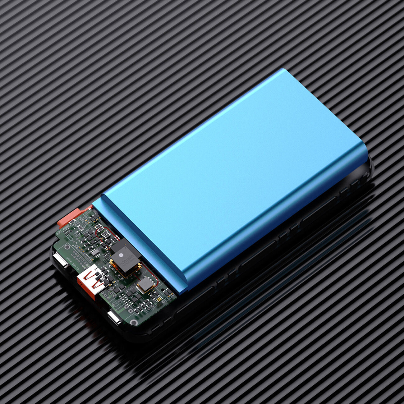 Obraz przedstawia powerbank z widoczną częścią wewnętrznej elektroniki i niebieską obudową na czarnym, prążkowanym tle.